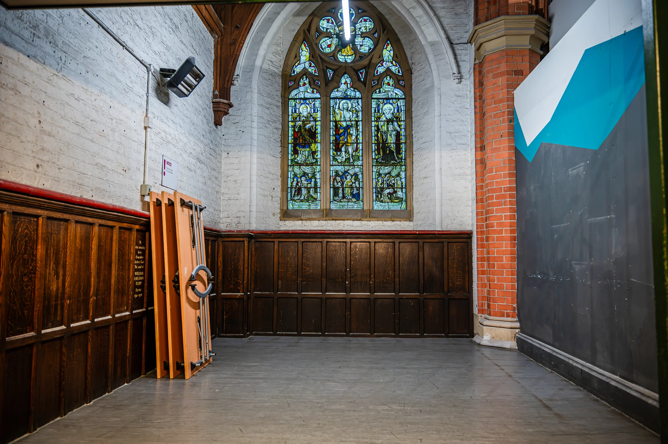 The area intended for the kitchen, with a stained-glass window above timber panelling
