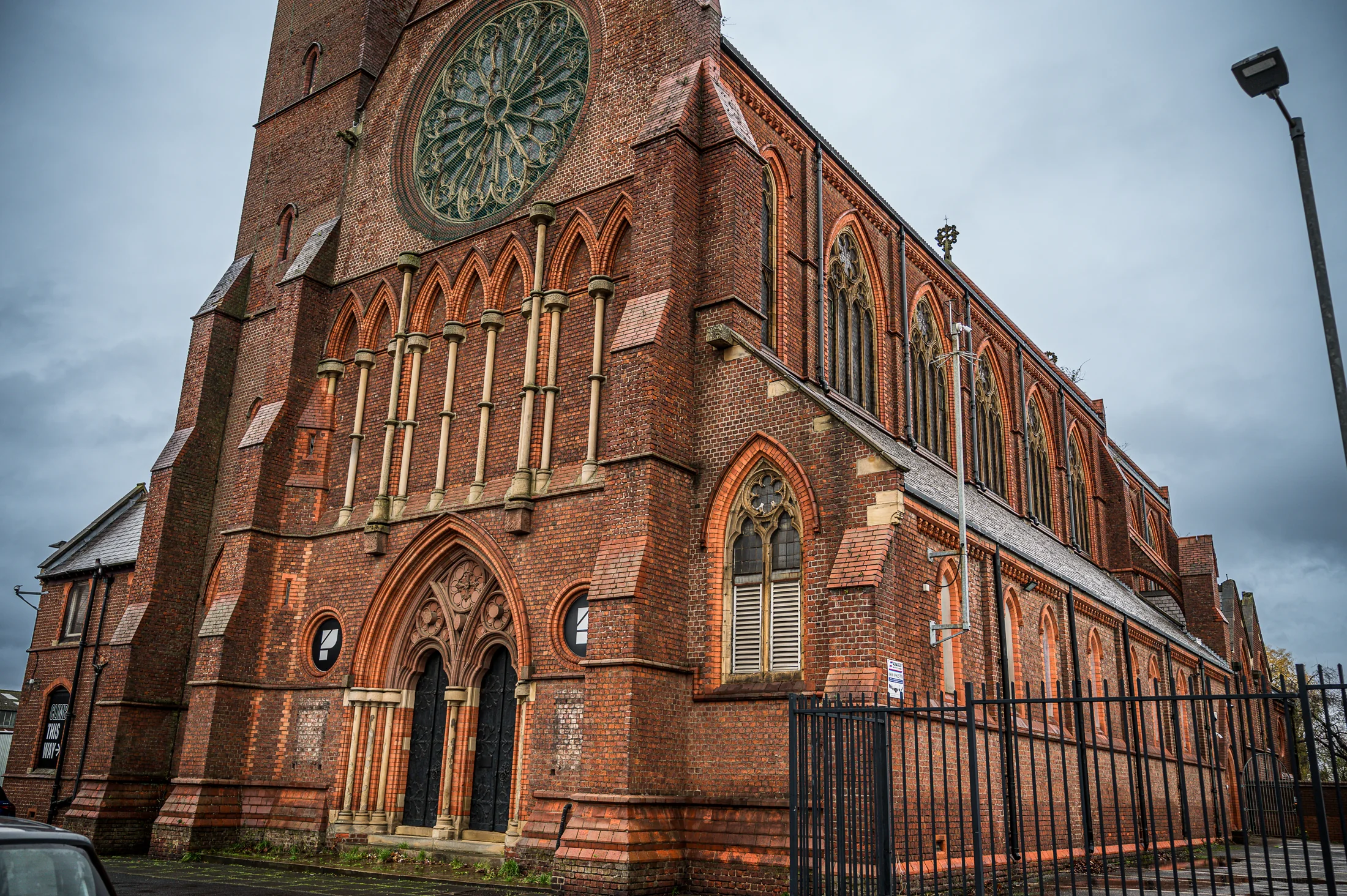 The red-brick exterior of St Benedict’s, with its tower and rose window