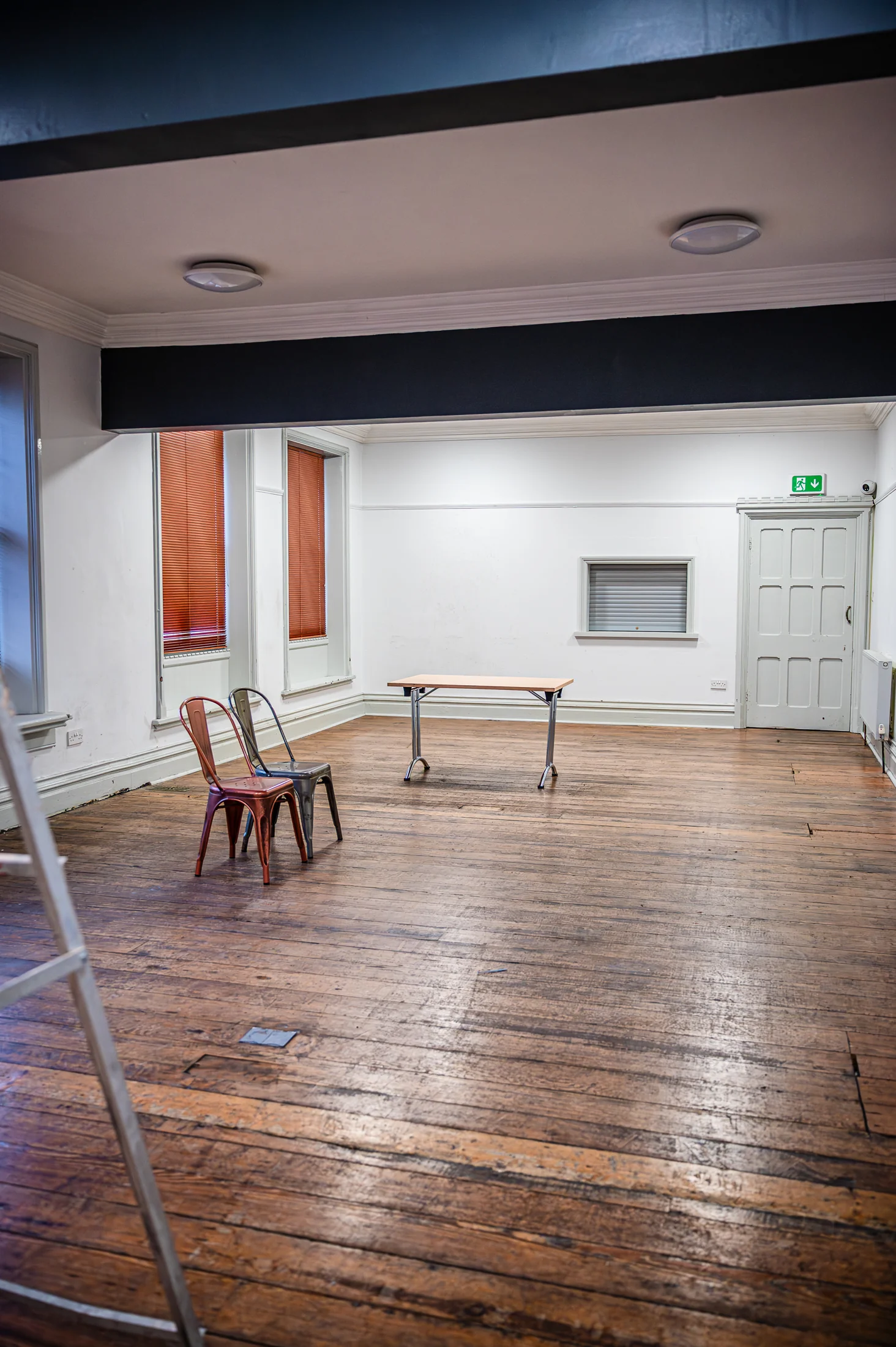 An existing room with timber flooring and a fireplace